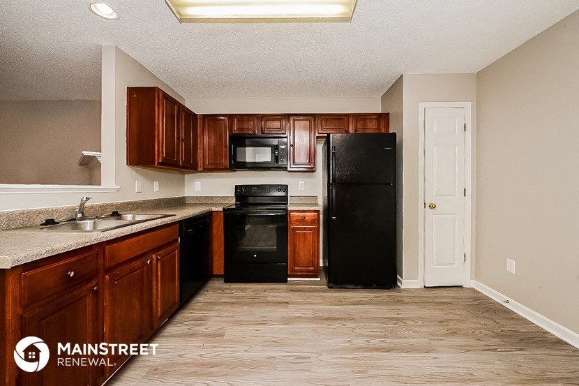 a kitchen with black appliances and wooden cabinets