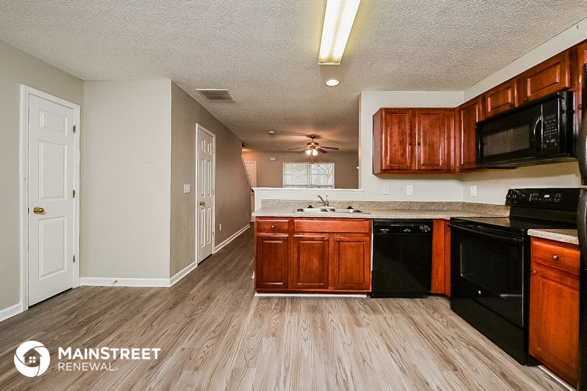 a kitchen with black appliances and wooden cabinets