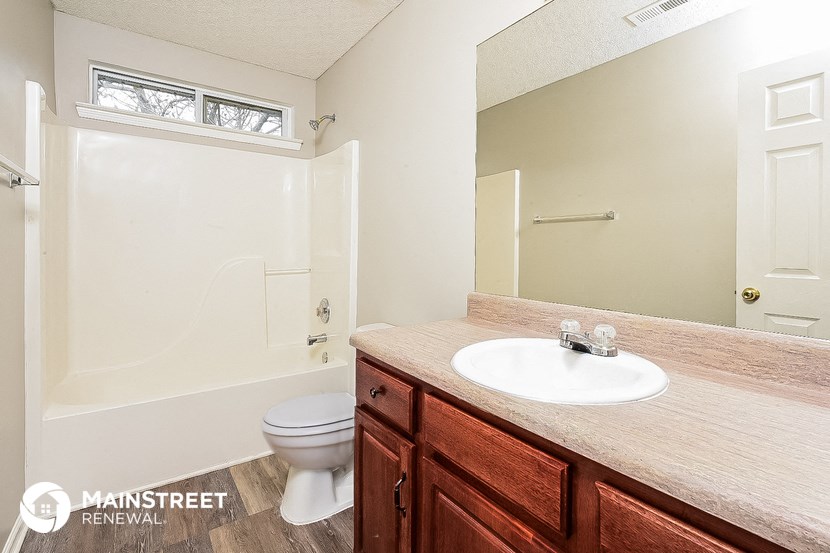 a bathroom with a toilet and a sink and a mirror