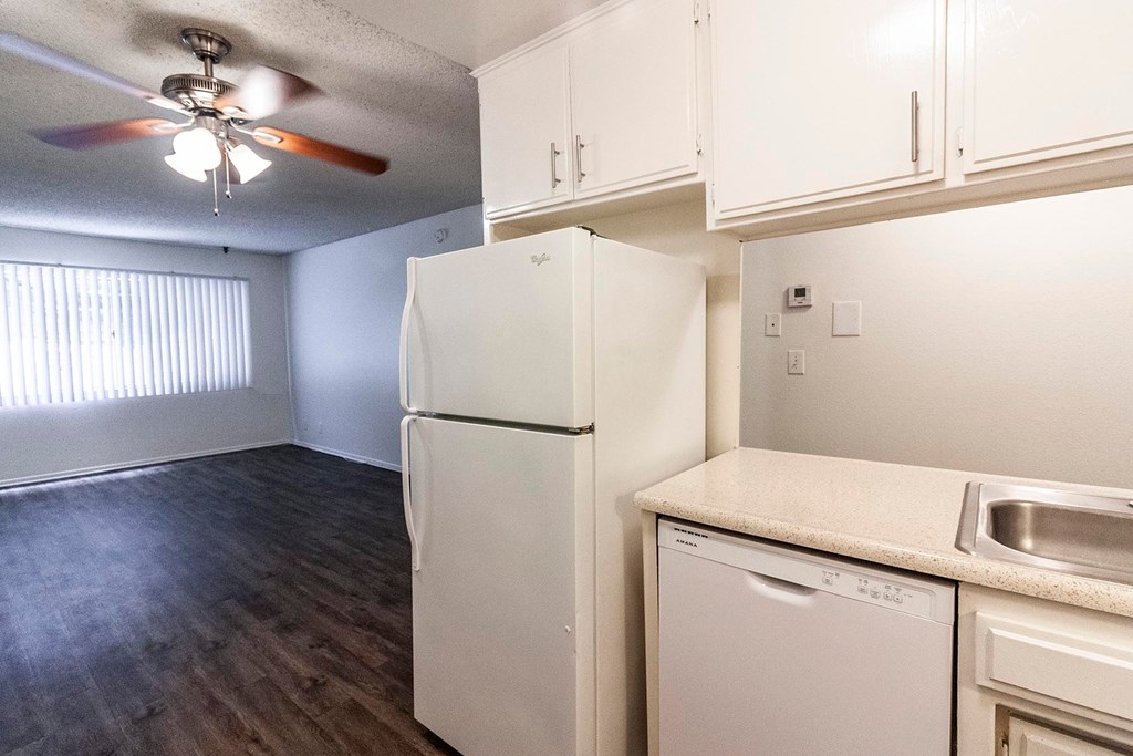 A kitchen with a white refrigerator, dishwasher, and stove.