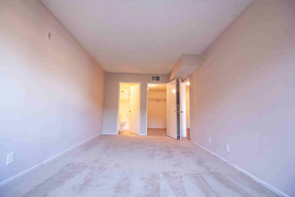 A long, empty hallway with a carpeted floor and white walls.