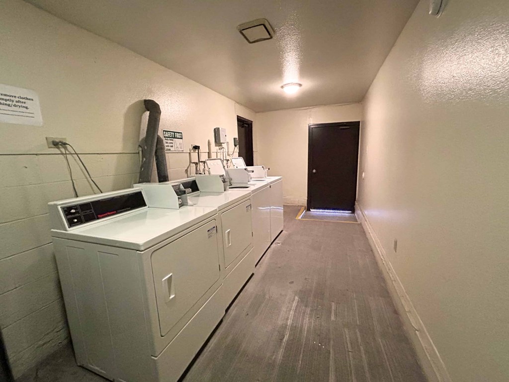 A long white room with a black door at the end.