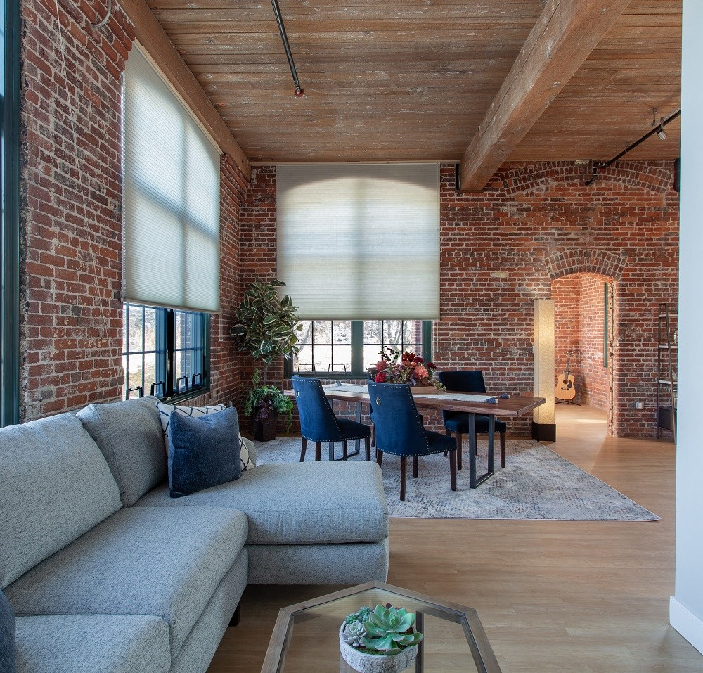 a living room with a couch and a table and a brick wall