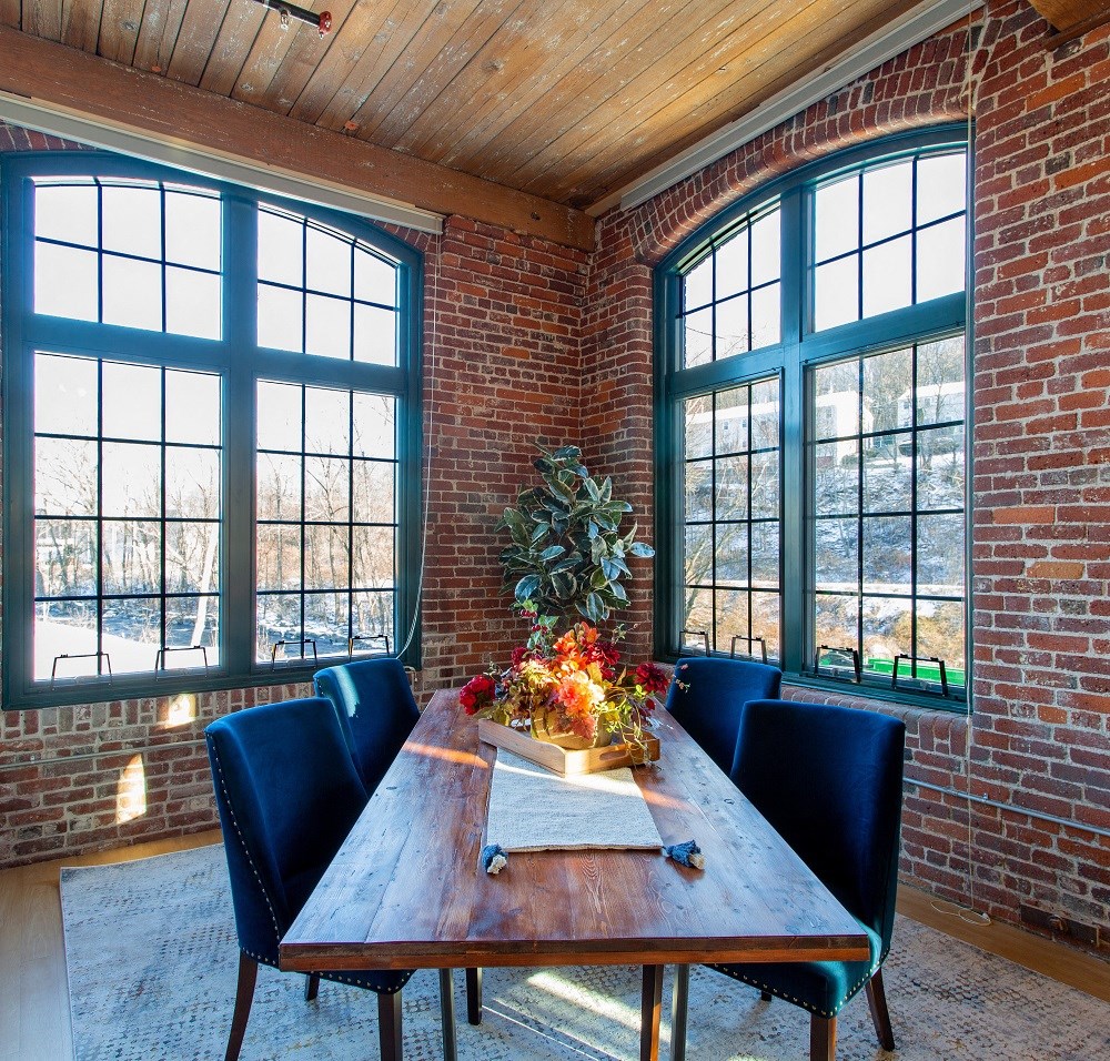 a dining room with large windows and a wooden table