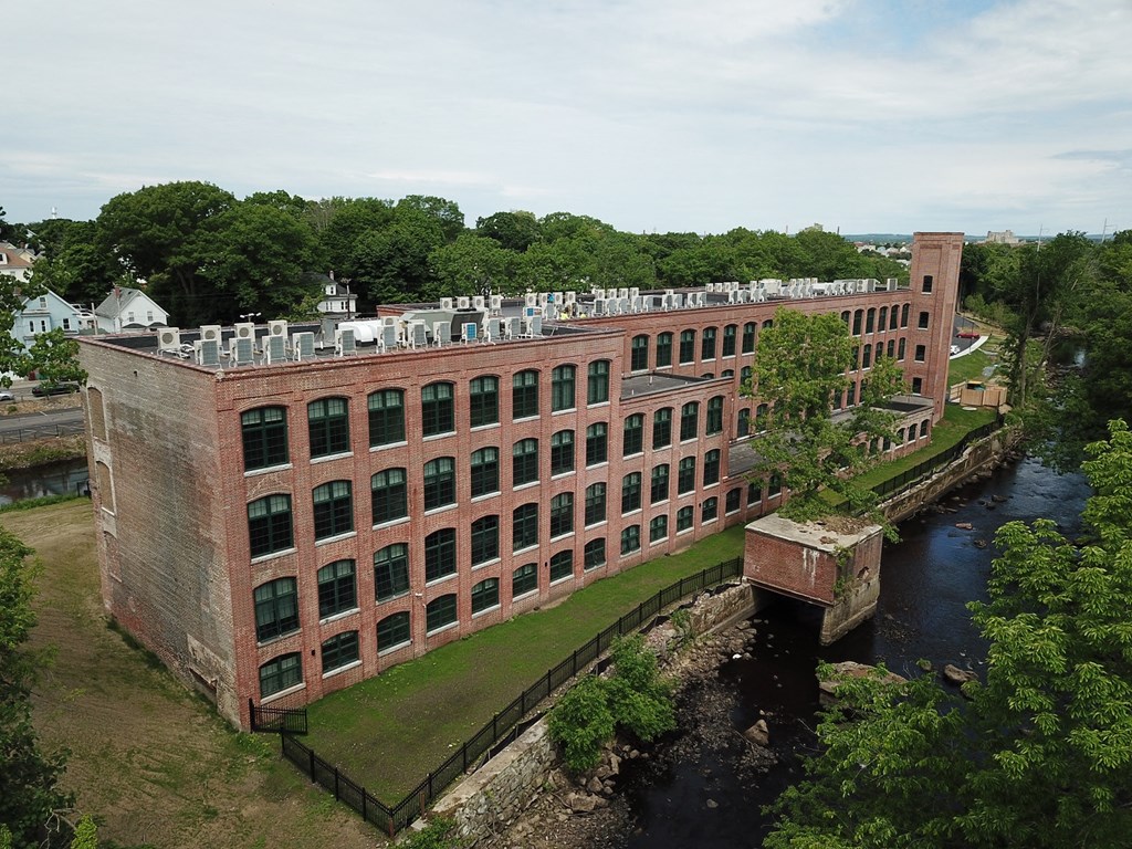 an aerial view of a brick building next to a river