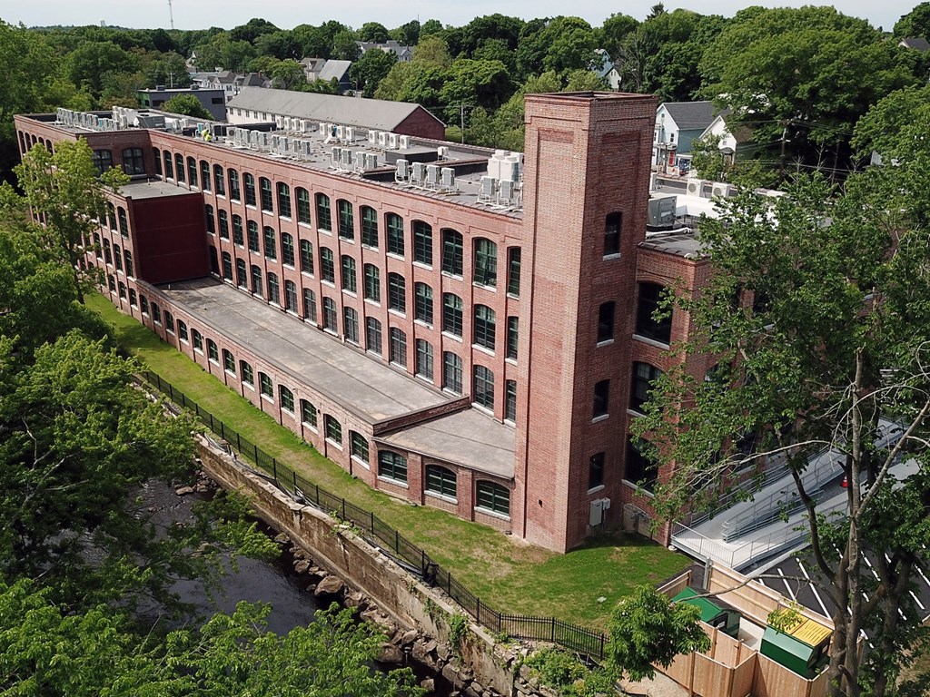 an aerial view of a large brick building surrounded by trees