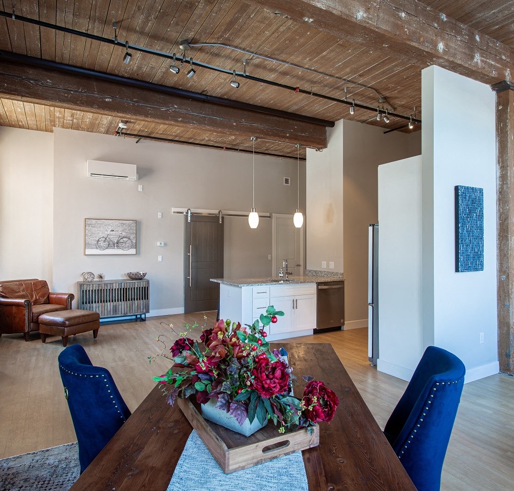 a living room and dining room with a wooden table and chairs
