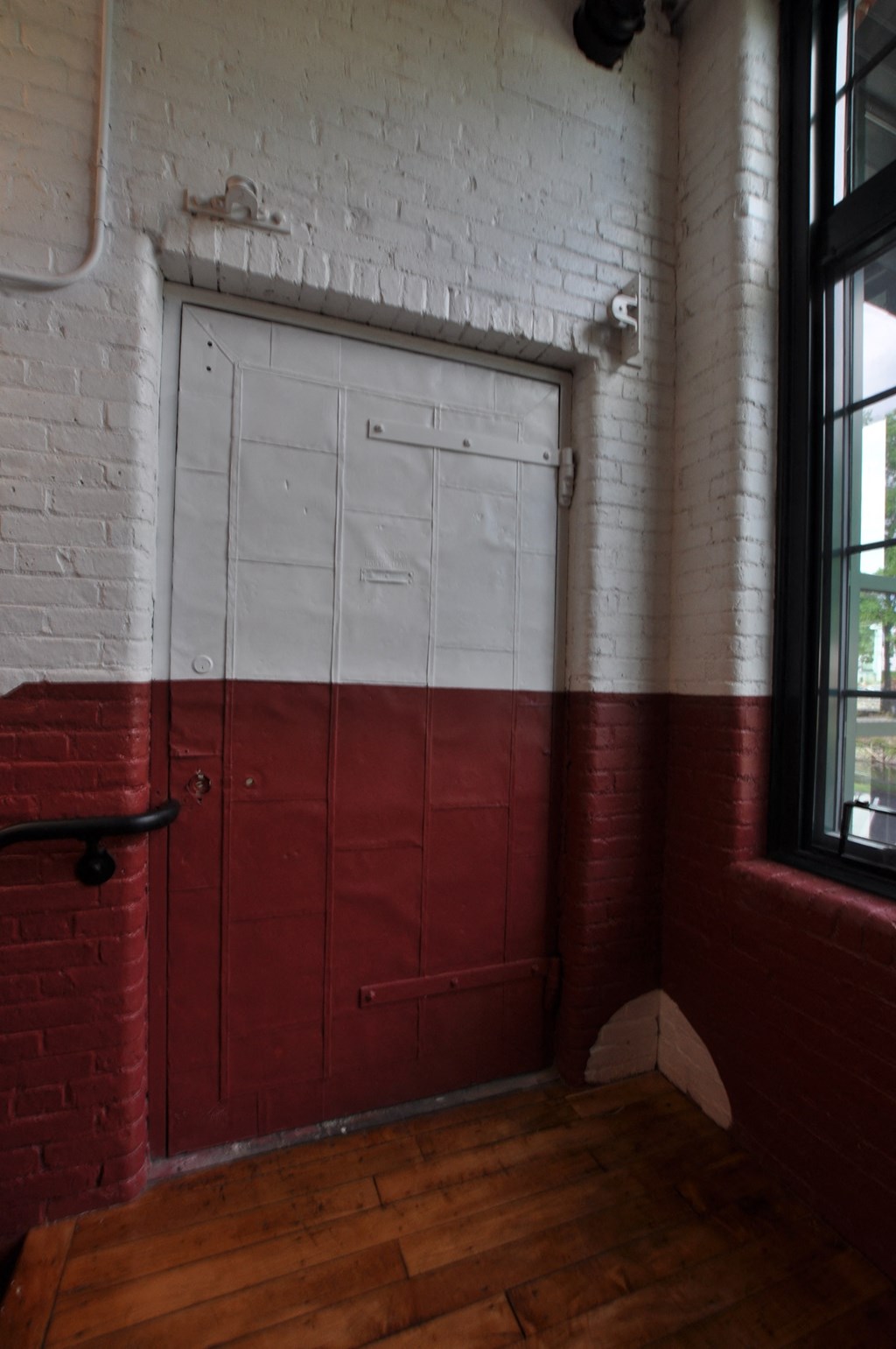 a door in a brick wall in a room with a wood floor