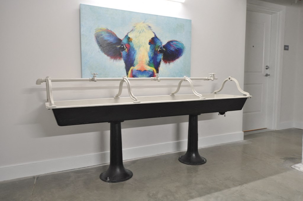 a large painting of a cow on top of a sink