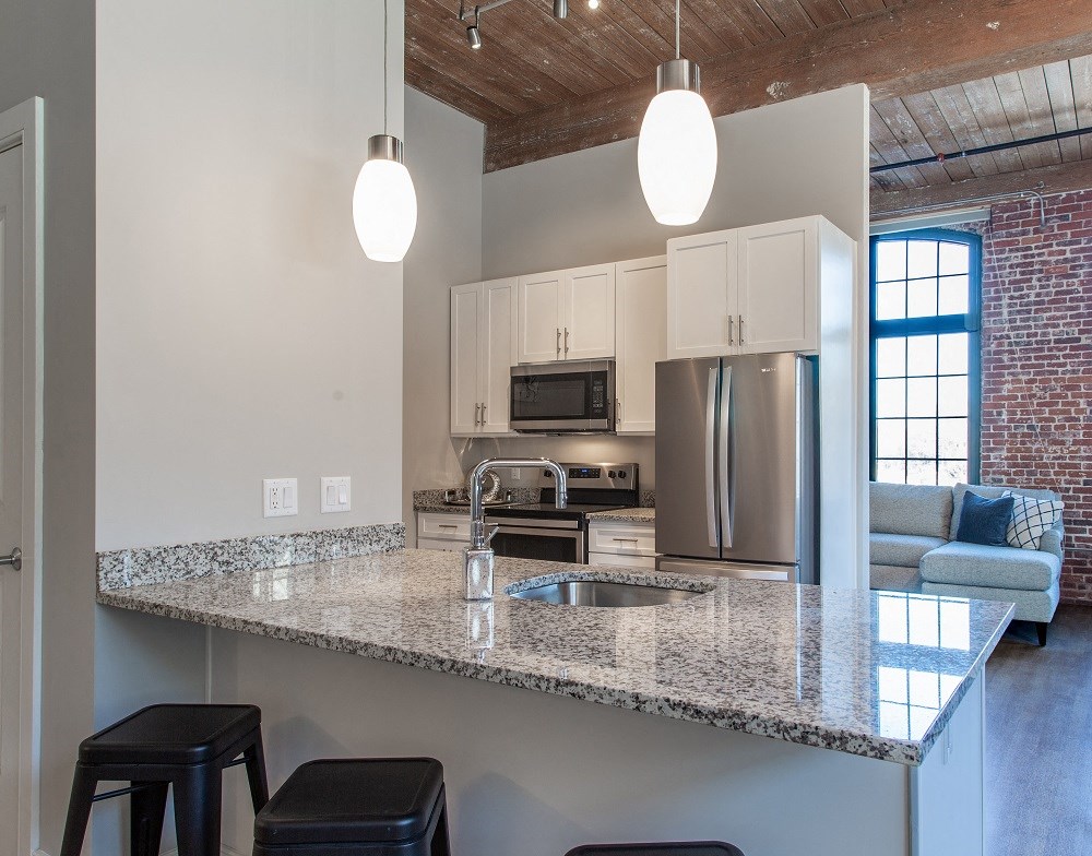a kitchen with a granite counter top and an island with stools