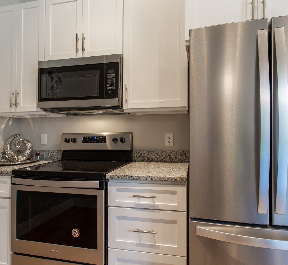 a kitchen with stainless steel appliances and white cabinets