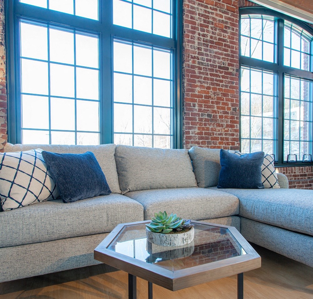 a living room with a couch and a coffee table in front of windows