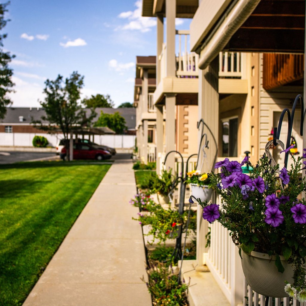 A red car is parked on the street in front of a house.