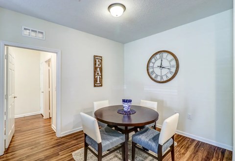 A dining room with a table set for four.