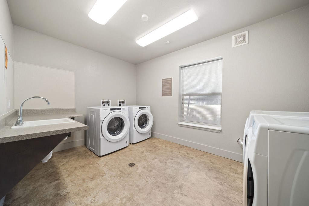 a laundry room with a washer and dryer and a window