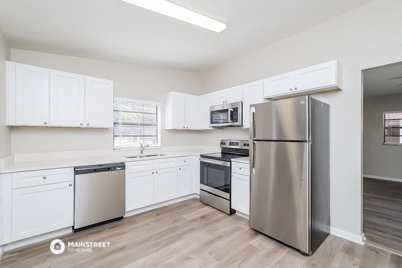 a white kitchen with stainless steel appliances and white cabinets