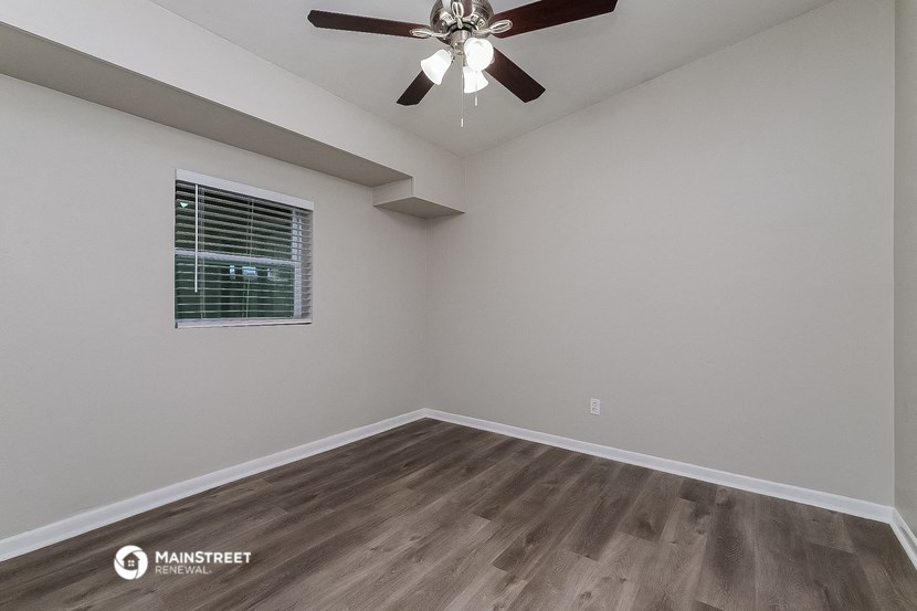 a bedroom with a ceiling fan and a window