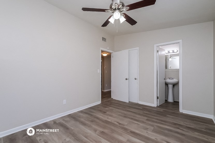 the living room of an apartment with a ceiling fan