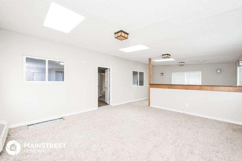 an empty living room with white walls and a white carpet
