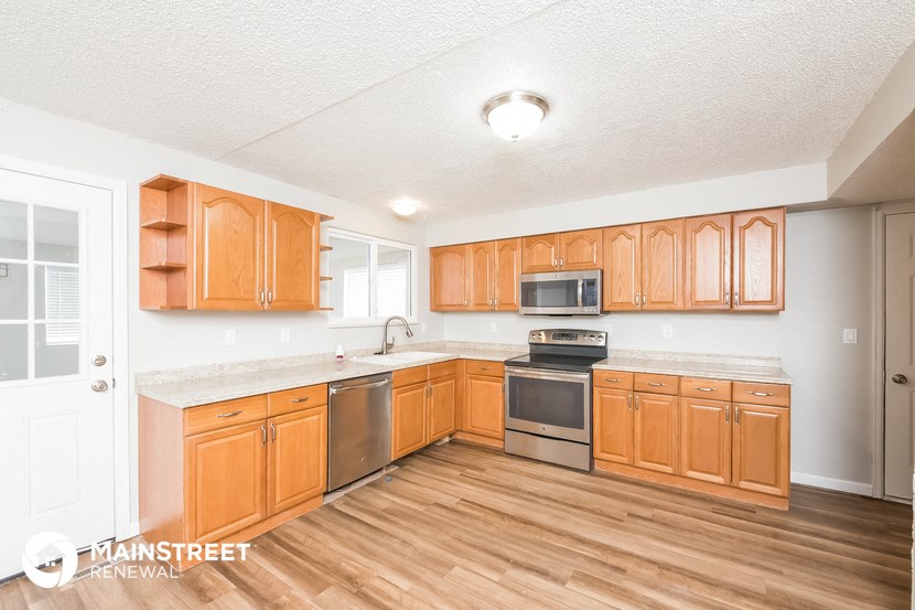 a kitchen with wooden cabinets and stainless steel appliances