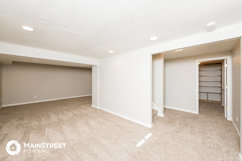 an empty basement with a closet and a door to a shoe closet