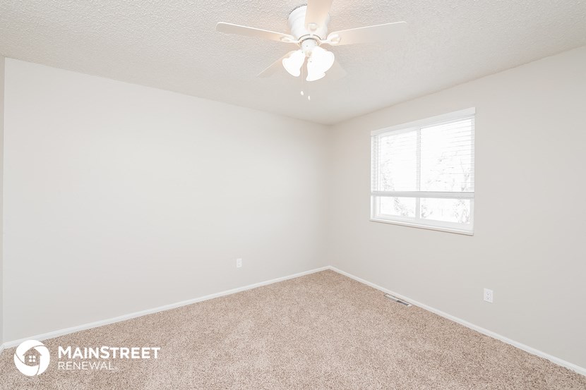 a bedroom with a ceiling fan and a window