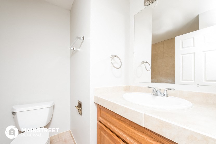 a bathroom with a toilet and a sink and a mirror