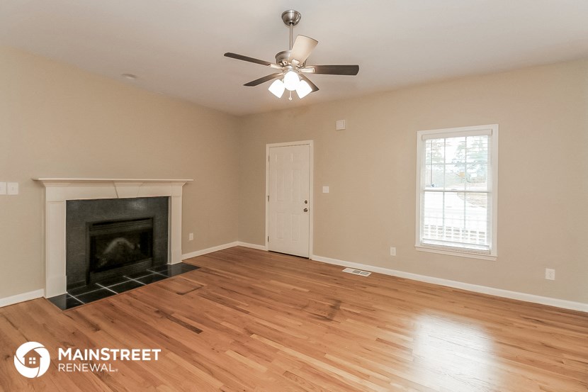 the living room with fireplace and ceiling fan