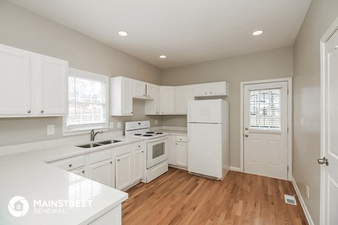 a kitchen with white cabinets and white appliances and a white refrigerator