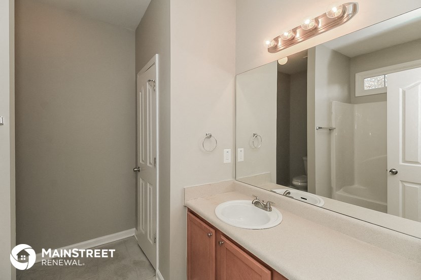 the bathroom has a large mirror and a sink