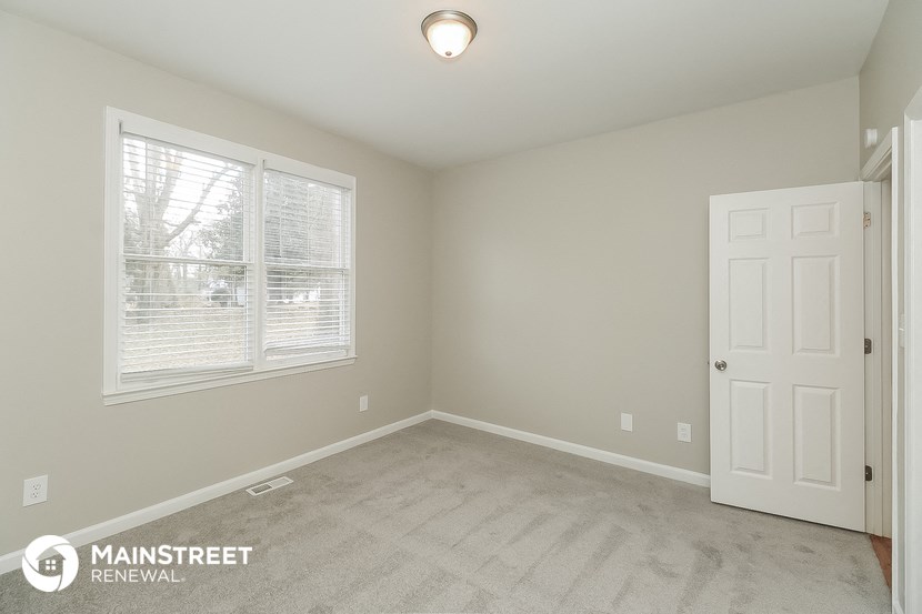 the master bedroom has a carpeted floor and a white door