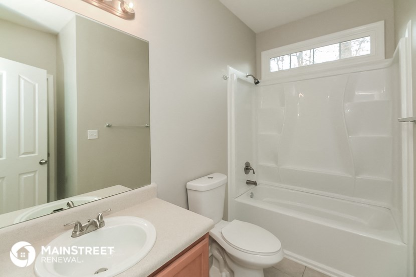 a white bathroom with a shower toilet and sink