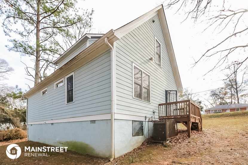 the exterior of a white house with a porch and a deck