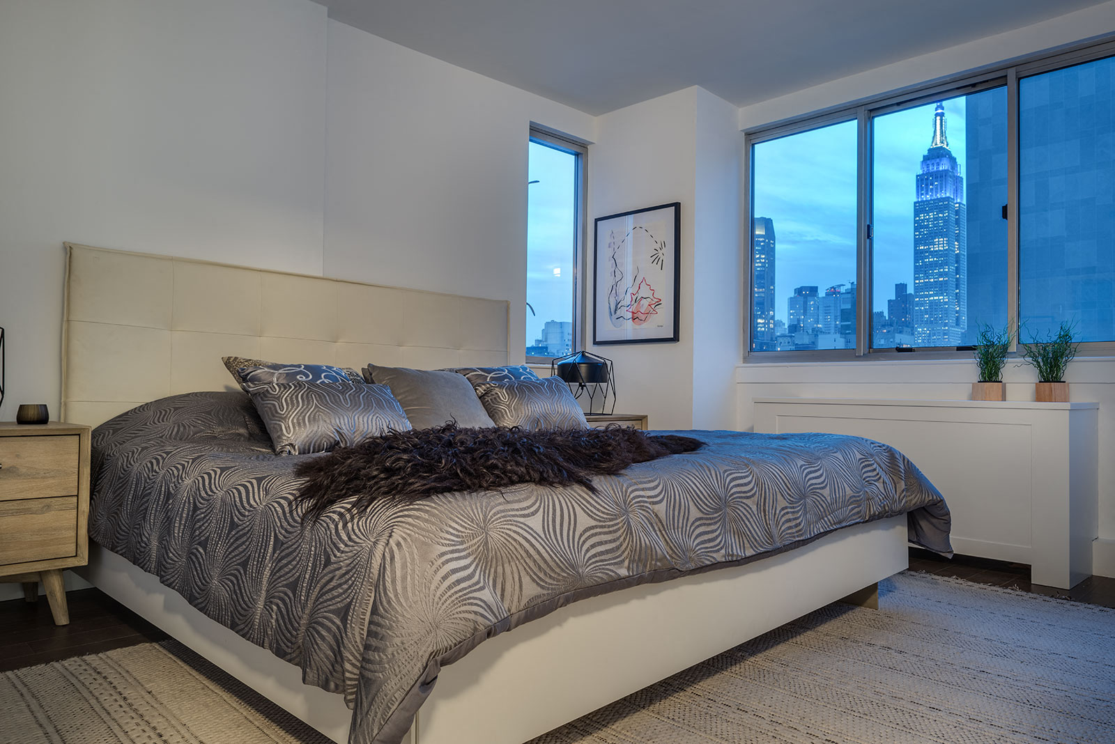a bedroom with a bed and a view of the empire state building