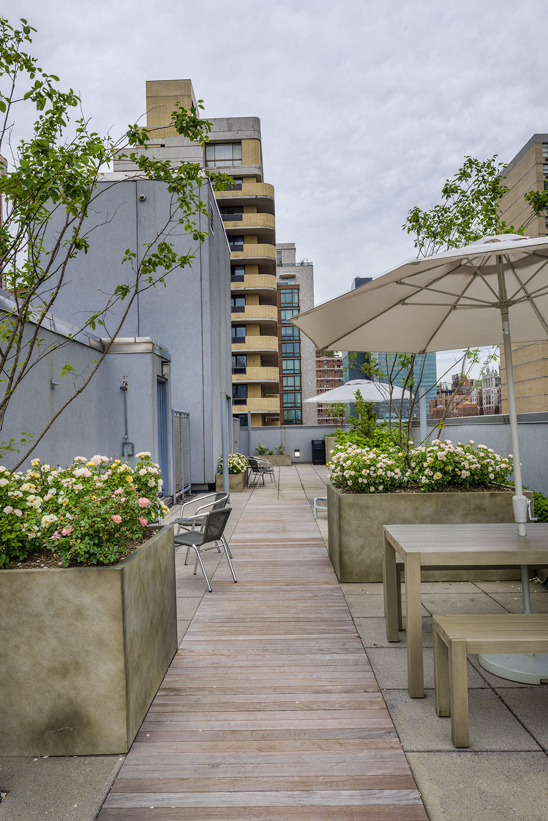 a roof terrace with tables and chairs and umbrellas