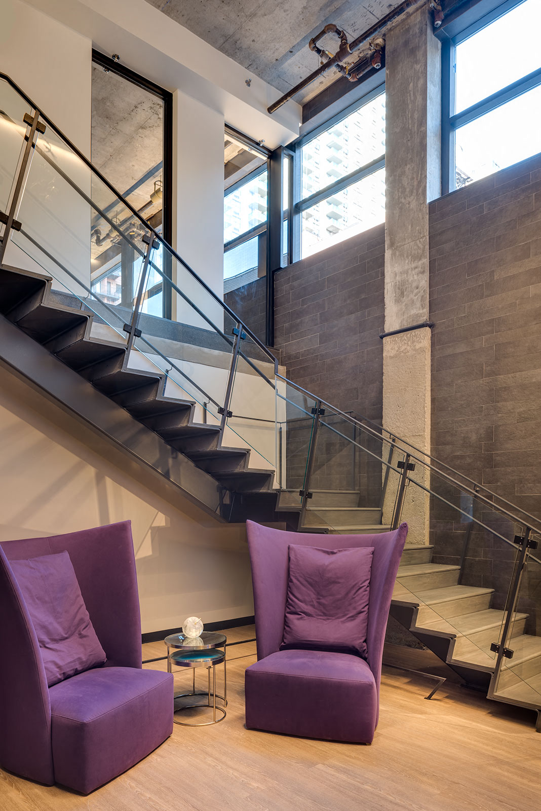 a living room with two purple chairs and a staircase