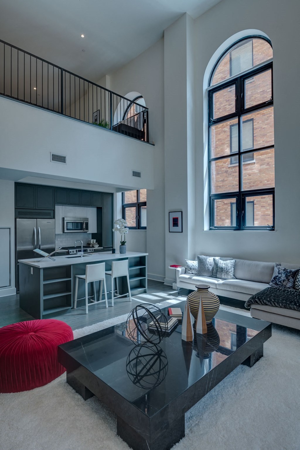 a living room with a glass coffee table and a kitchen