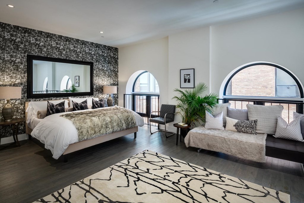 a bedroom with a bed and a couch and a window