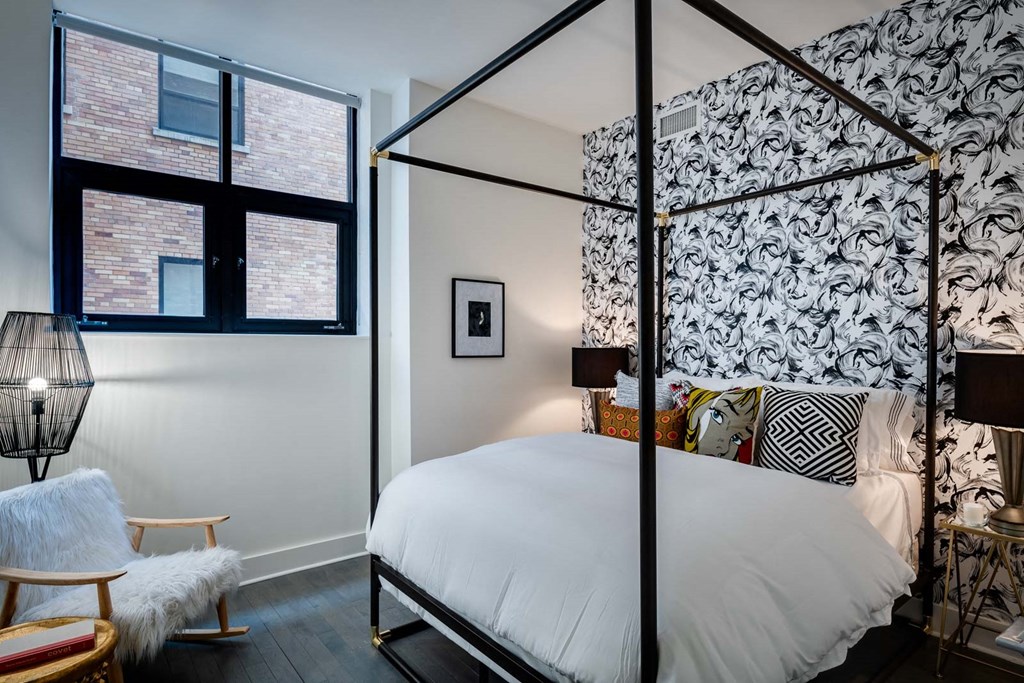 a bedroom with a canopy bed and a black and white wallpaper