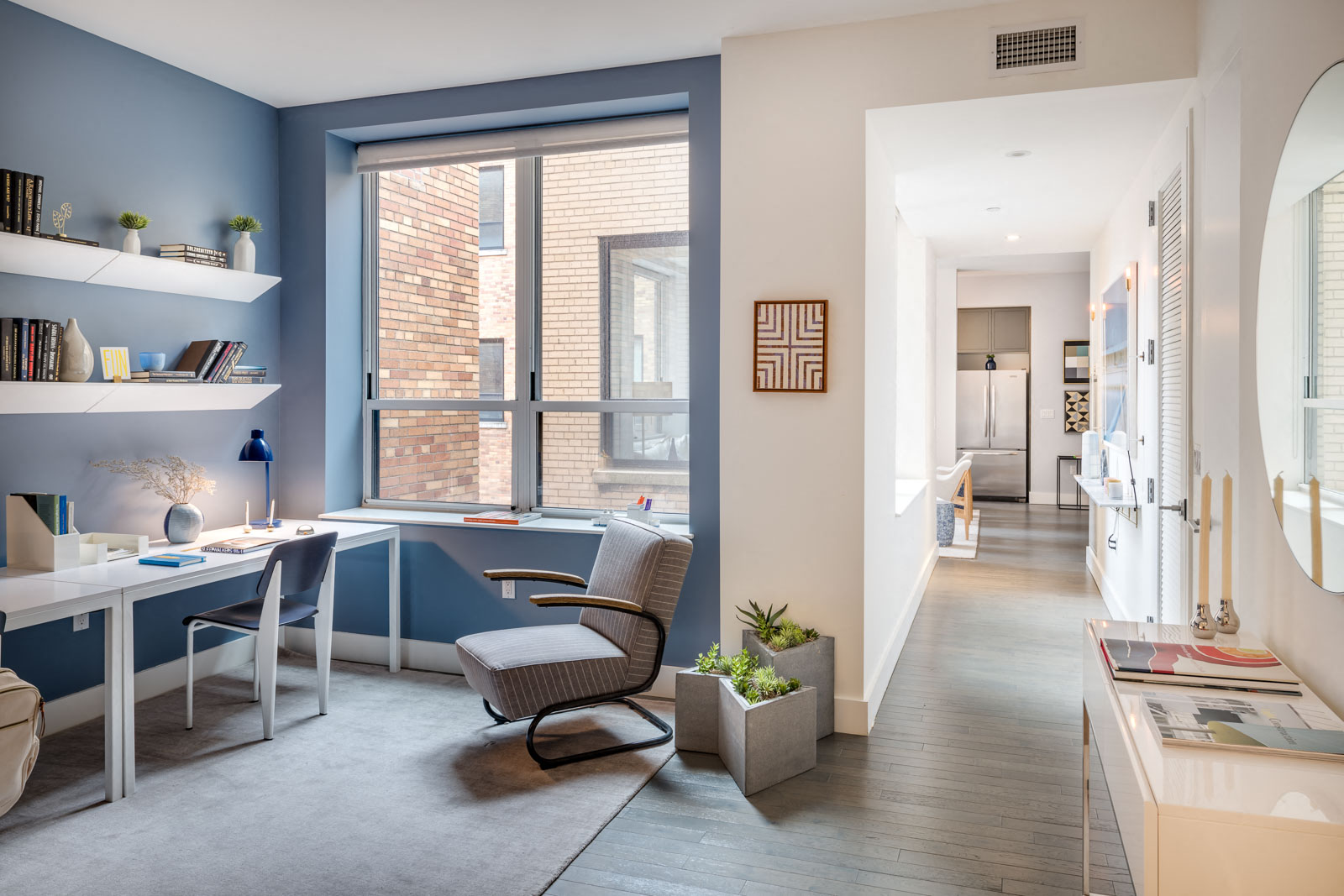 a home office with a large window and a desk with a chair