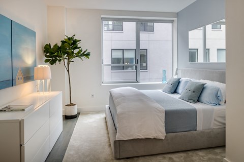 a bedroom with a bed and a large window