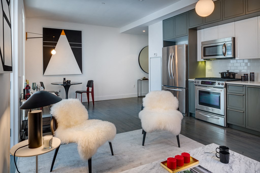 a kitchen and living room with white chairs and a table