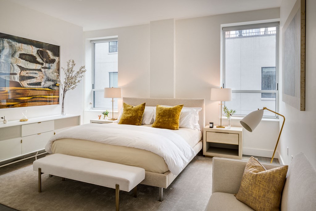 a bedroom with a bed and a chair and a window