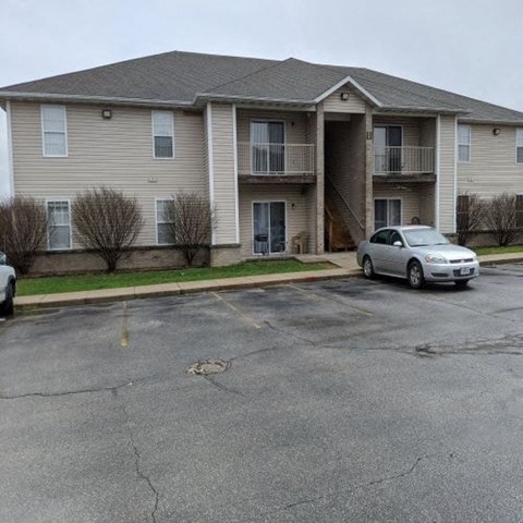 a apartment building with a car parked in a parking lot