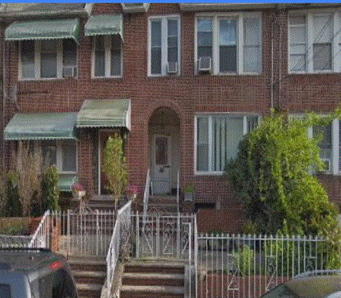 a red brick house with a white fence in front of it