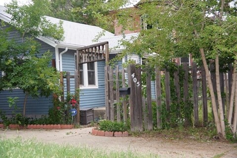 a blue house with a wooden fence in front of it