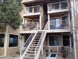 the outside of a building with stairs and balconies
