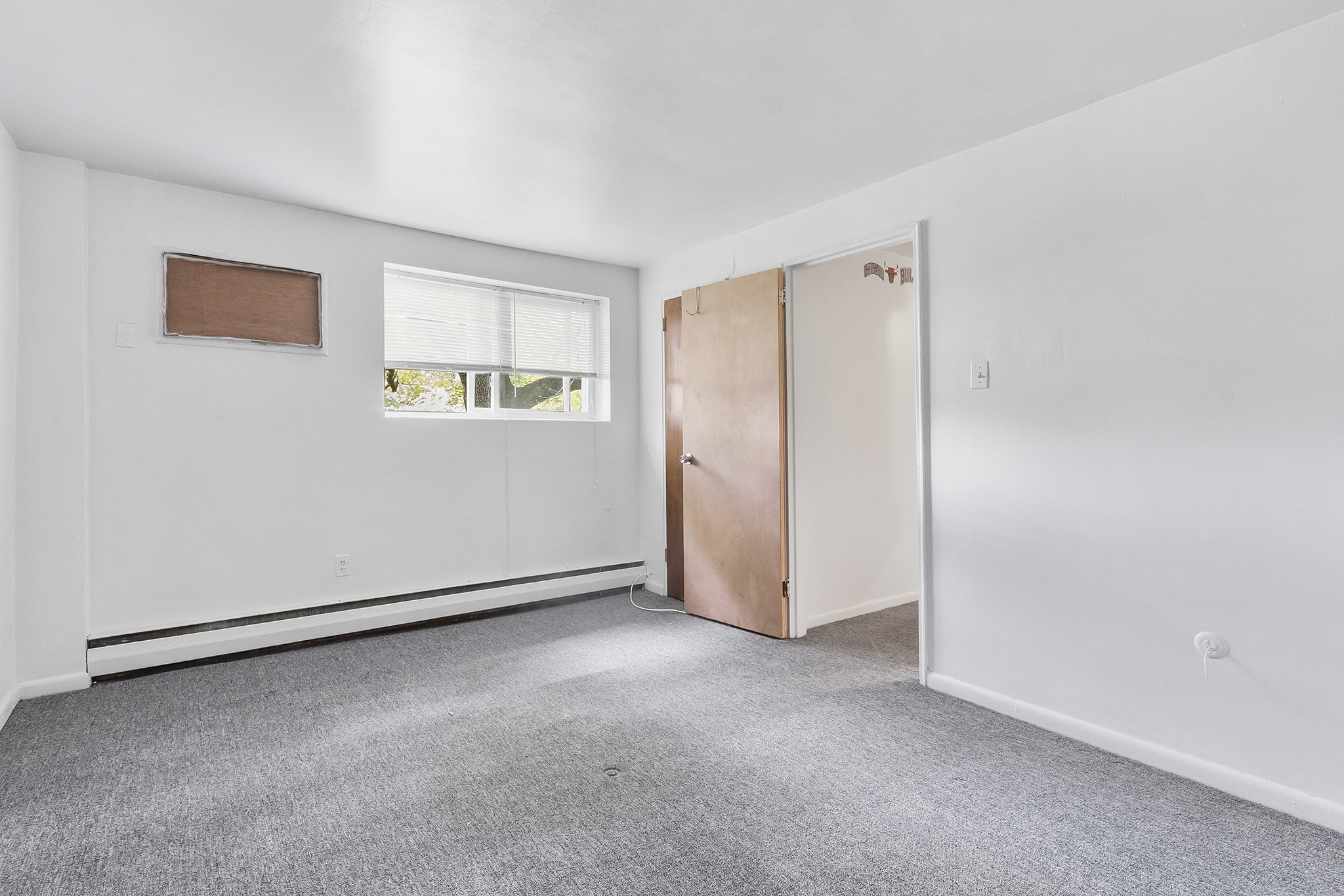 an empty room with white walls and a window and a door