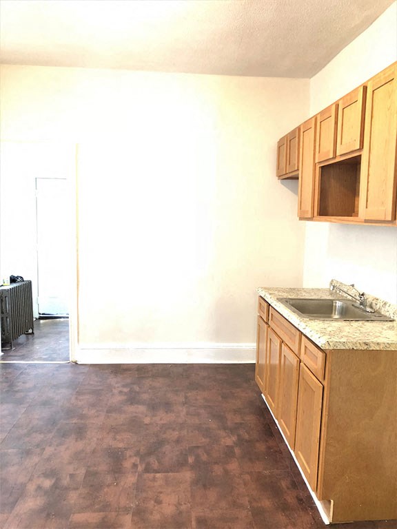 an empty kitchen with wooden cabinets and a sink