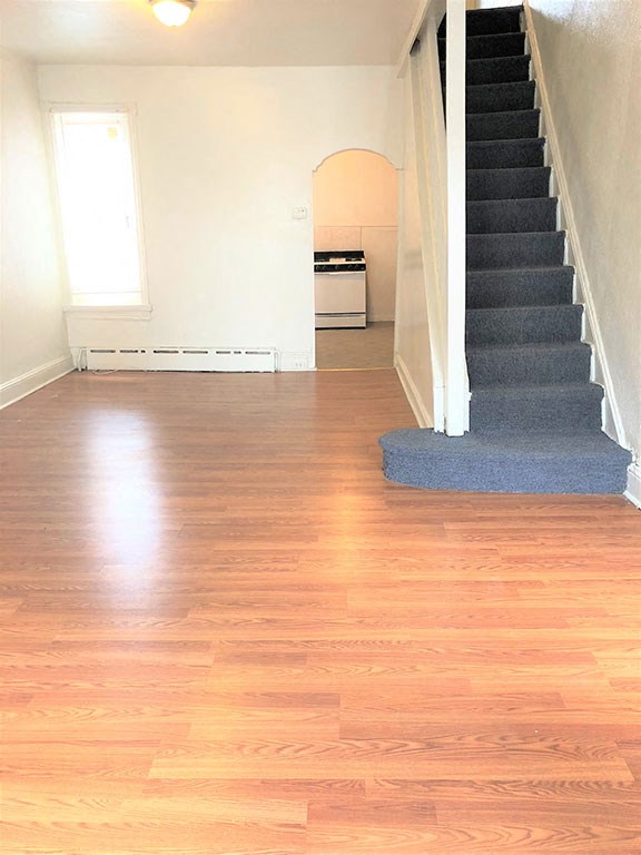 a living room with a staircase and a hard wood floor